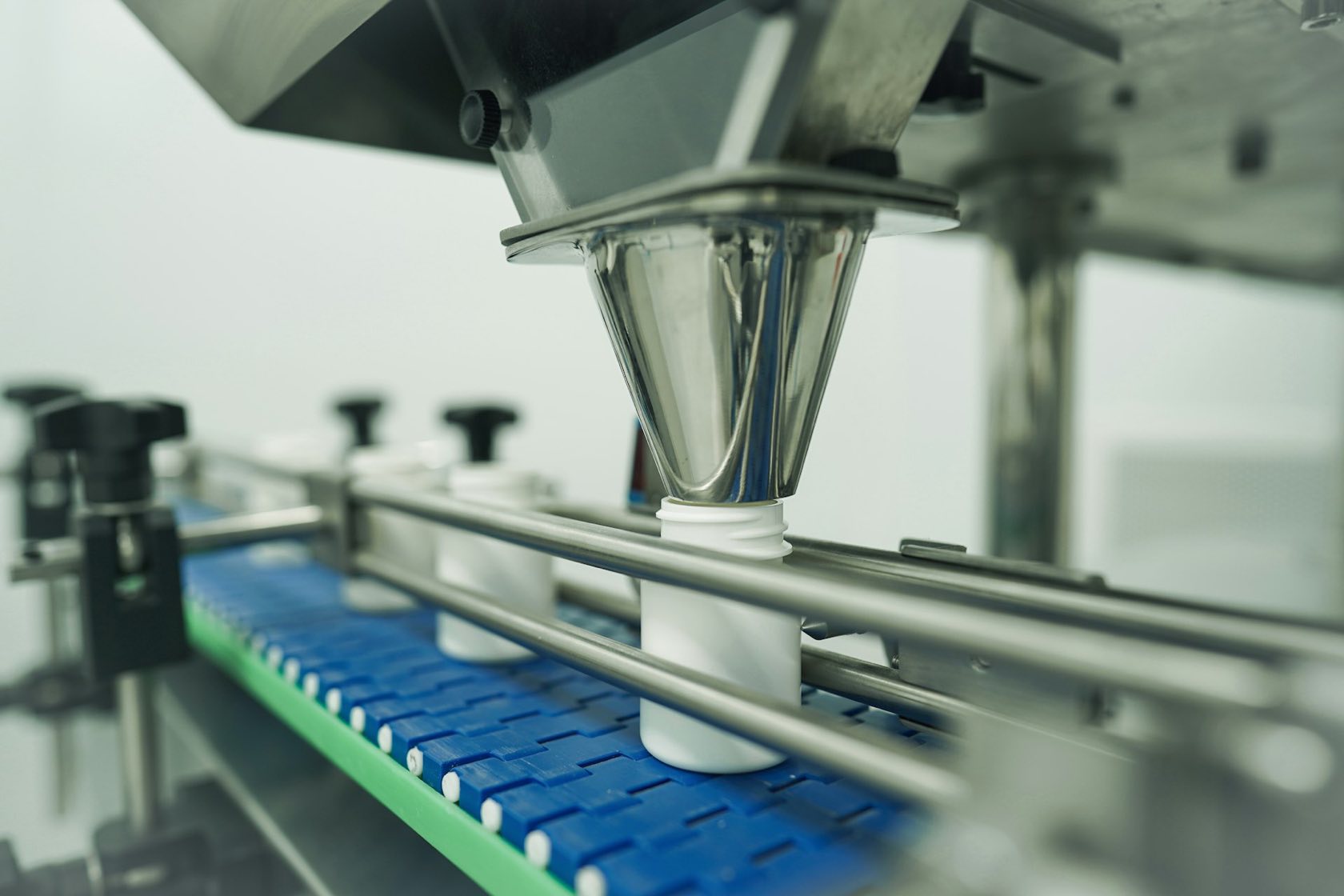 Automatic filling station above plastic bottles on a conveyor