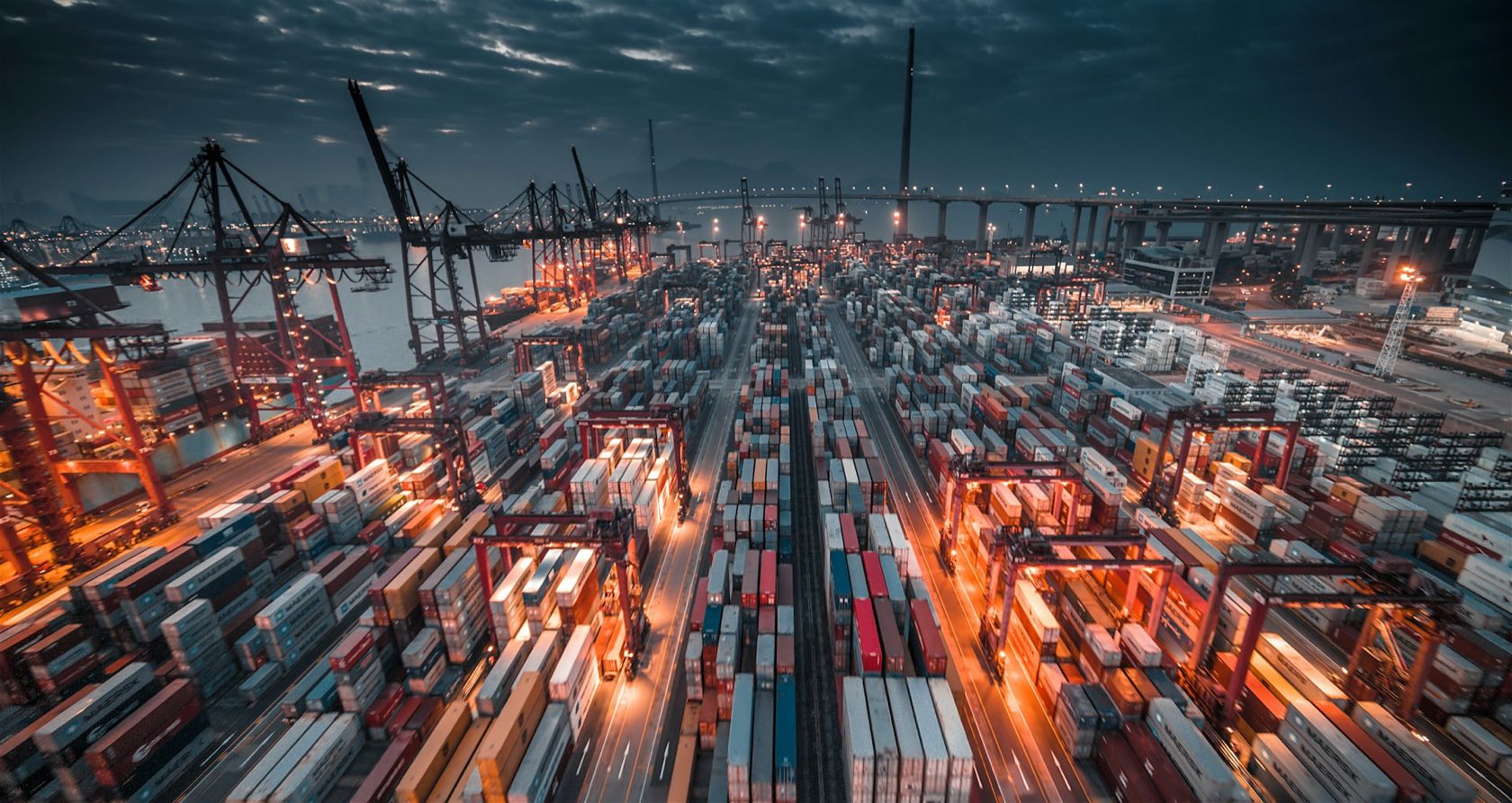 Aerial view of a container terminal with ship-to-shore cranes and stacked containers